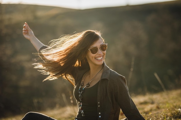 Una foto de una joven alegre disfrutando del aire libre.