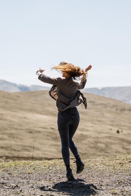 Una foto de una joven alegre disfrutando del aire libre.