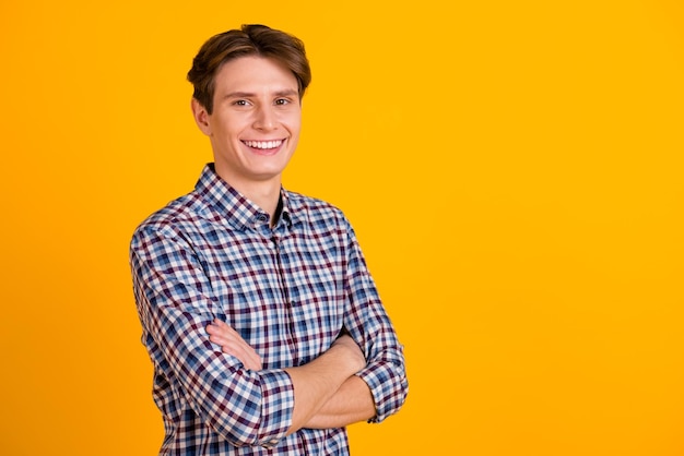Foto de un joven alegre, feliz sonrisa positiva, gerente de agente cruzó las manos aisladas sobre un fondo de color amarillo