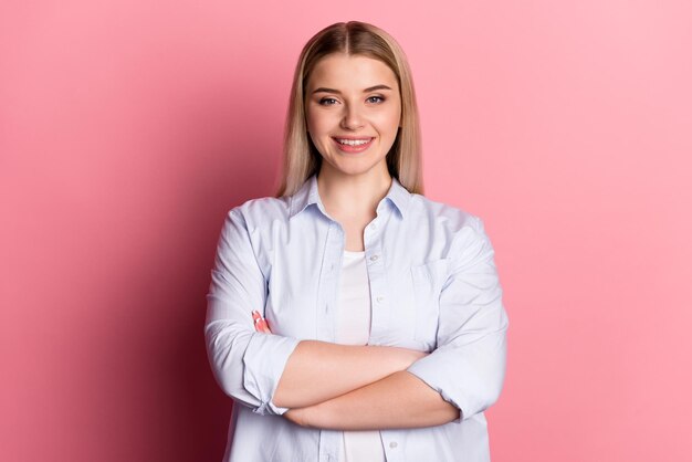 Foto de una joven alegre con las manos dobladas agente banquero representante aislado sobre fondo de color rosa