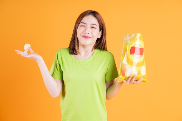 Foto de una joven asiática comiendo un bocadillo en el fondo