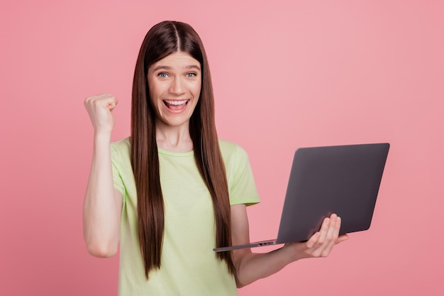 Foto de joven atractiva sonrisa feliz positvie usando laptop escribiendo e-mail aislado sobre fondo de color rosa pastel