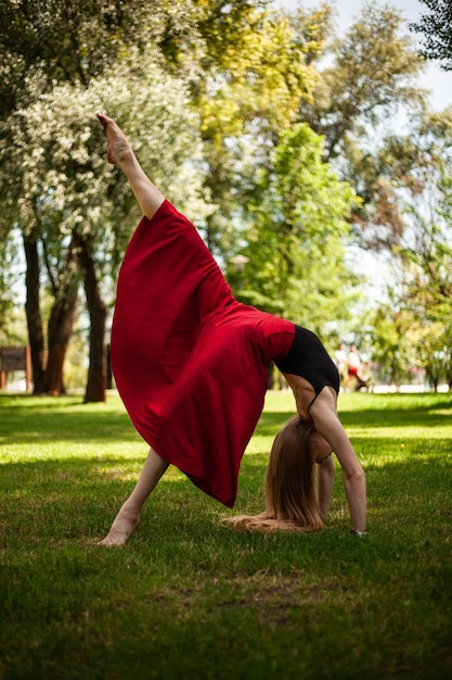 Foto de una joven bailarina del vientre en un parque una joven rubia está bailando en la naturaleza niña gimnasta