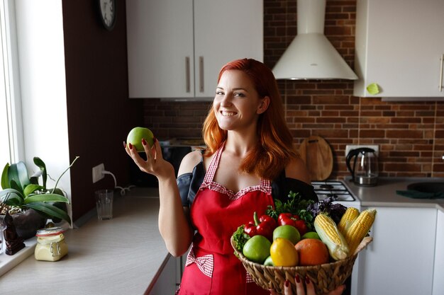 Foto de una joven dama bonita parada en la cocina mientras cocina pescado Mujer preparando comida saludable en su rústica cocina ecológica