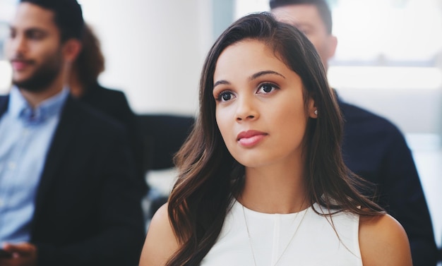 Foto de una joven empresaria sentada en la audiencia de una conferencia de negocios