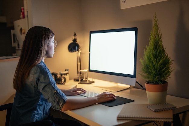 Foto de una joven empresaria trabajando en una computadora en la noche en casa.