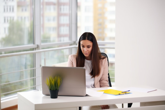 Foto de una joven empresaria trabajando con un portátil en su lugar de trabajo