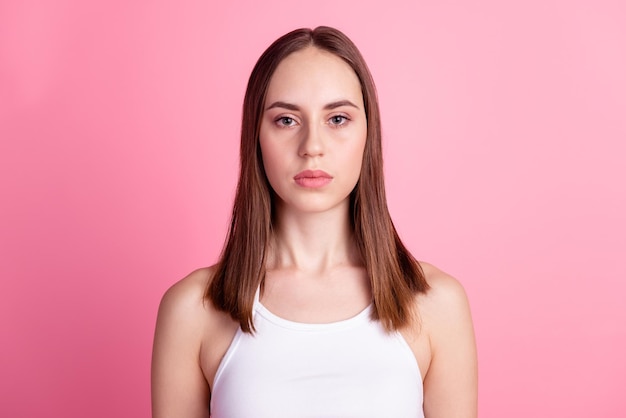 Foto de una joven encantadora chica segura de sí misma en un salón de belleza cosmetología aislada sobre un fondo de color rosa