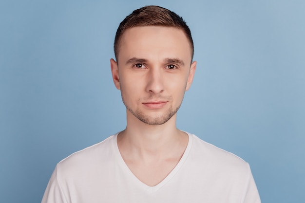 Foto de joven guapo serio camiseta de desgaste centrado confianza aislado sobre fondo de color azul