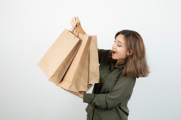 Una foto de una joven modelo con bolsas artesanales sobre blanco. foto de alta calidad