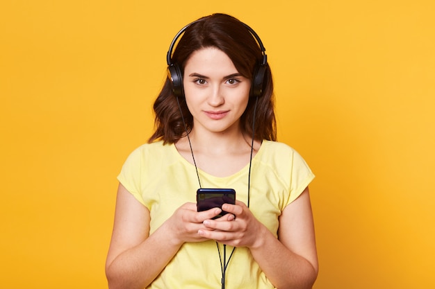 Foto de joven morena con auriculares, lista para escuchar música