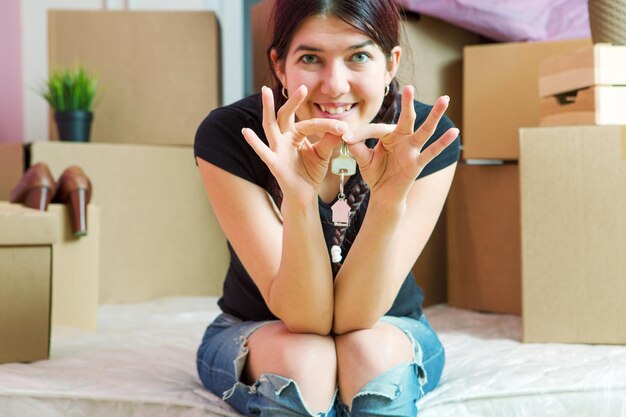 Foto de joven morena con llaves de apartamento en apartamento