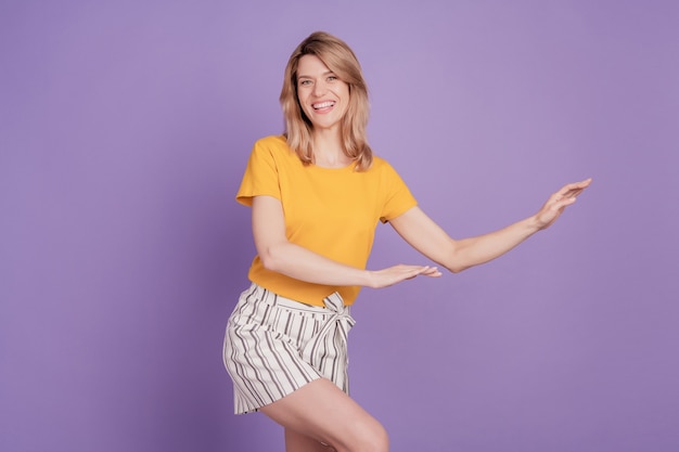 Foto de joven mujer atractiva feliz sonrisa positiva baile fiesta discoteca aislado sobre fondo de color violeta