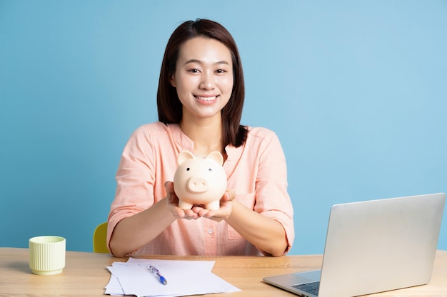 Foto de una joven mujer de negocios asiática en fondo azul
