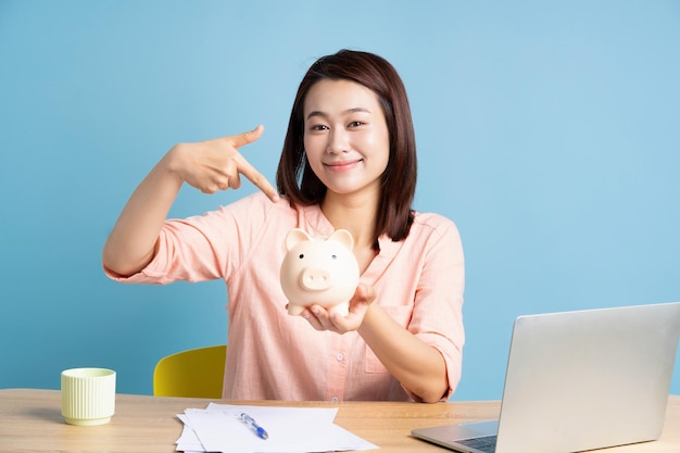 Foto de una joven mujer de negocios asiática en fondo azul