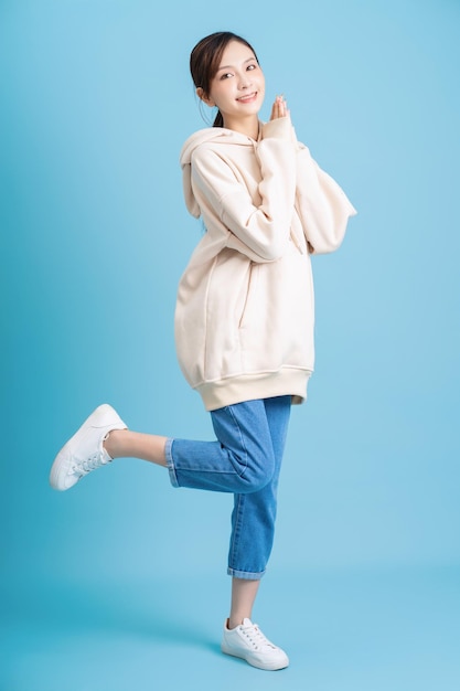 foto, de, joven, niña asiática, posar, en, fondo azul