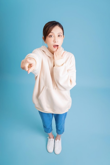 foto, de, joven, niña asiática, posar, en, fondo azul