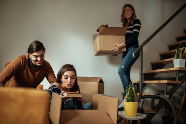 Una foto de jóvenes amigos alegres que se mudan de casa