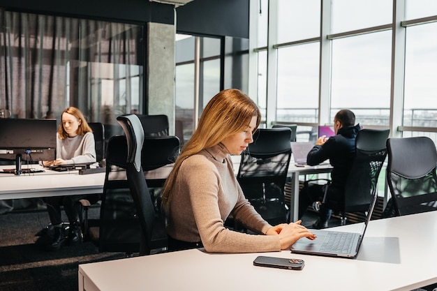 Foto de jóvenes trabajando en una computadora en una moderna oficina de coworking