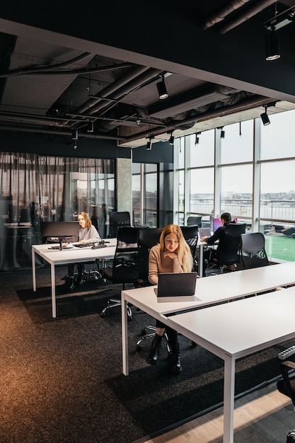 Foto de jóvenes trabajando en una computadora en una moderna oficina de coworking