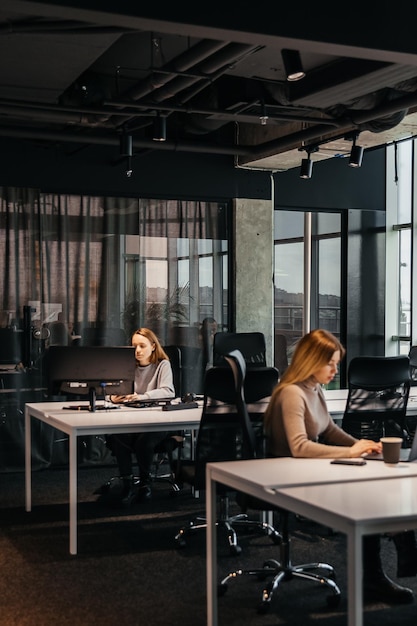 Foto de jóvenes trabajando en una computadora en una moderna oficina de coworking