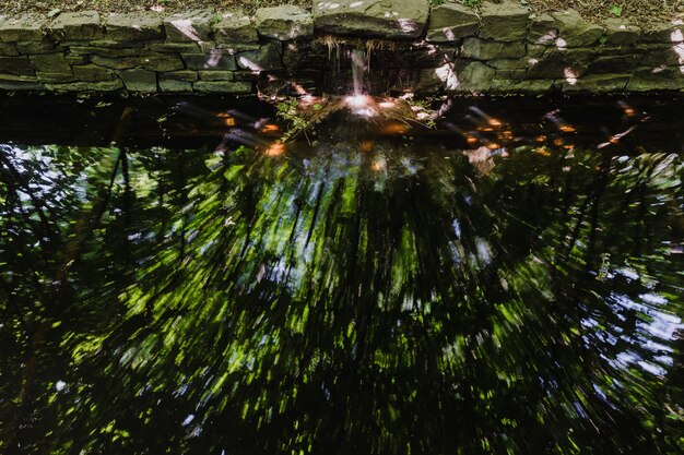 Foto de larga exposición de arroyo de jardín con reflejo colorido.