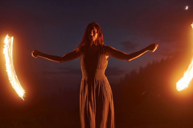 Foto con una larga exposición Espectáculo de fuego de una mujer vestida en la noche Montañas Cárfatas Hermoso paisaje