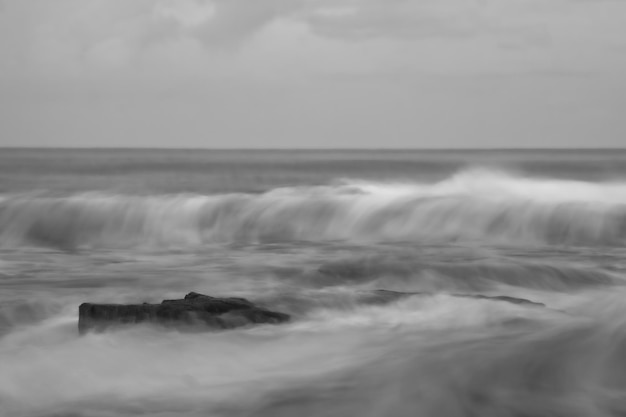 Foto de larga exposición de la playa con olas y rocas