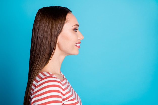 Foto lateral de perfil de una chica agradable y atractiva, buen humor, copyspace, disfruta de escuchar a un amigo, usa una camisa de estilo casual aislado sobre fondo de color azul