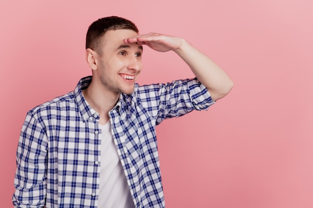 Foto lateral de perfil del joven sorprendido sorprendido sorprendido sonrisa feliz mirar hacia adelante aislado sobre fondo de color rosa