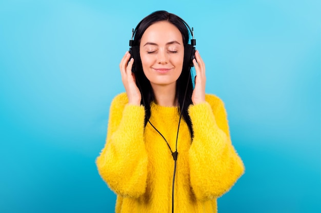 Foto de linda linda chica hermosa vestida con suéter amarillo manos tocar auriculares ojos cerrados