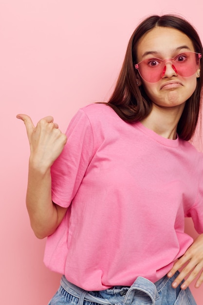 Foto linda mulher em óculos elegantes posando emoções fundo rosa