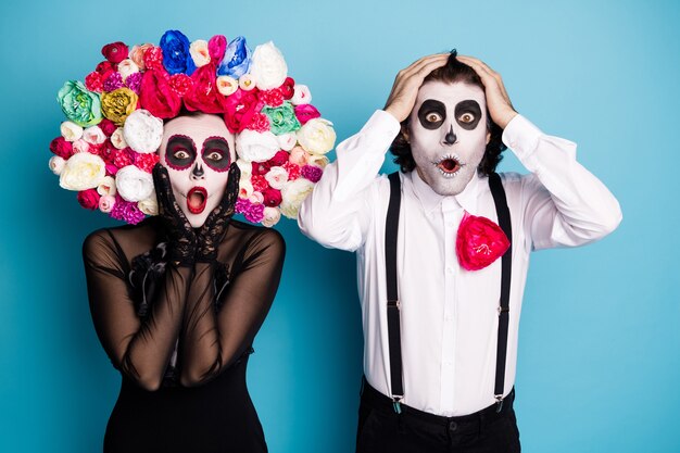 Foto de linda pareja fantasma hombre dama sorprendida boca abierta noticias increíble propuesta de tienda solo para muertos use vestido negro traje de muerte rosas diadema tirantes fondo de color azul aislado