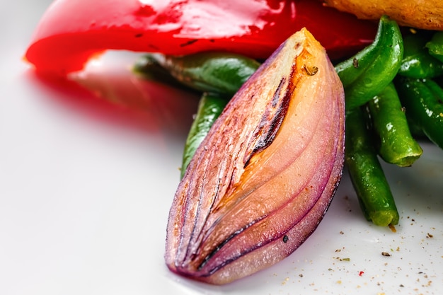 Foto macro de cebolla roja asada como parte de ensalada de verduras