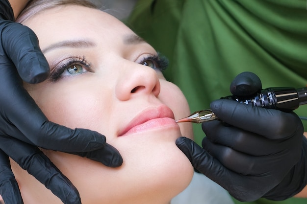 Foto macro do processo de aplicação da maquiagem definitiva de uma cor natural nos lábios de uma mulher.