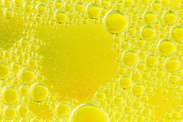 Foto macro hermosa y fantástica de gotas de agua en aceite con un amarillo