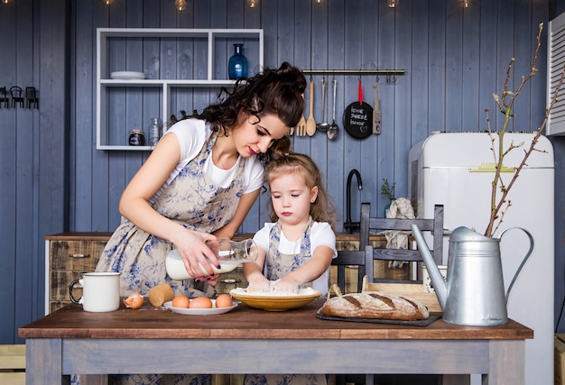 Foto de mamá e hija cocinar juntas en la cocina