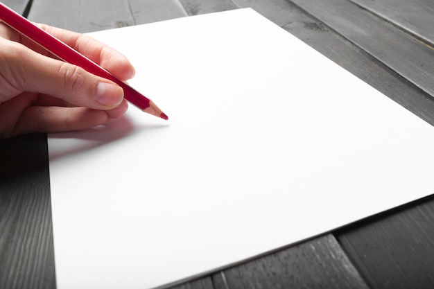 Foto de mano escribiendo en papel con lápiz de madera