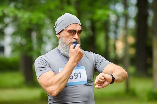 Foto média de um treinador esportivo profissional começando o treinamento de maratona com apitos