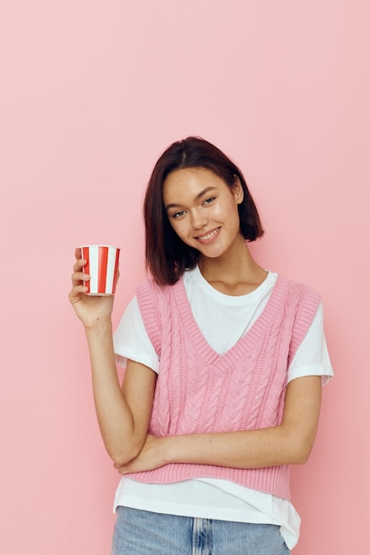 Foto menina bonita com um copo na mão estilo verão camiseta rosa isolado fundo