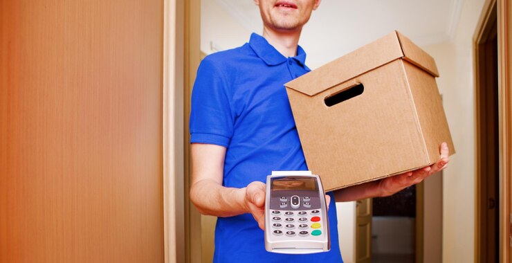 Foto foto de mensajero con caja de cartón en las manos y con terminal