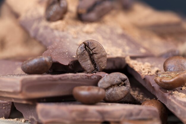 Foto mit Freizeitzutaten - Kakao und Kaffee, Schokoriegel mit Kakaopulver und Kaffeebohnen, Nahaufnahme von Kakaofutter