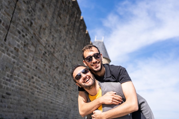 Foto mit Kopienraum eines homosexuellen Paares, das neben den Wänden einer mittelalterlichen Burg umarmt wird
