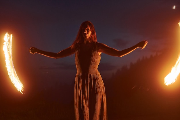 Foto mit Langzeitbelichtung Feuershow von Frau im Kleid in der Nacht Karpaten Schöne Landschaft