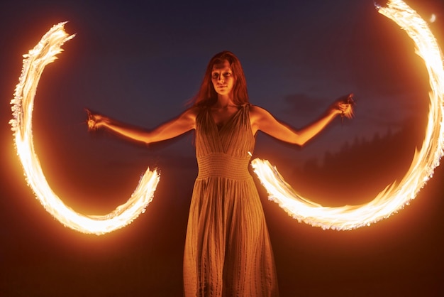 Foto mit Langzeitbelichtung Feuershow von Frau im Kleid in der Nacht Karpaten Schöne Landschaft