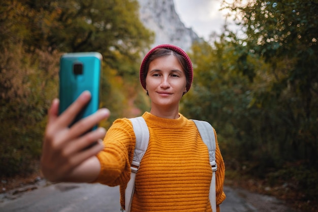 Foto de moda al aire libre de una joven bella dama rodeada de bosques otoñales en las montañas