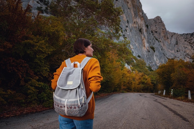 Foto de moda al aire libre de una joven bella dama rodeada de bosques otoñales en las montañas