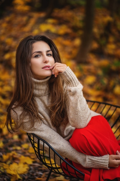 Foto de moda al aire libre de joven bella dama rodeada de hojas de otoño