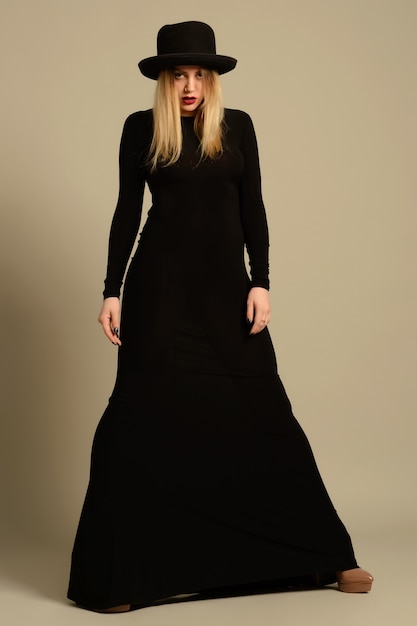 Foto de moda de hermosa dama en elegante vestido negro y sombrero