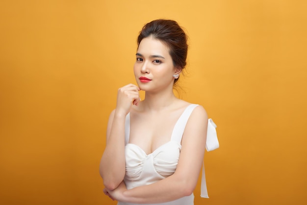 Foto de moda de una hermosa joven con un bonito vestido sobre fondo blanco.